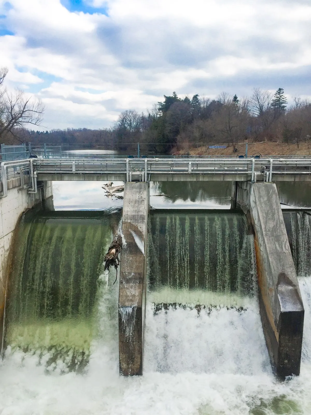 A dam in full spring flow with mist and whitewater